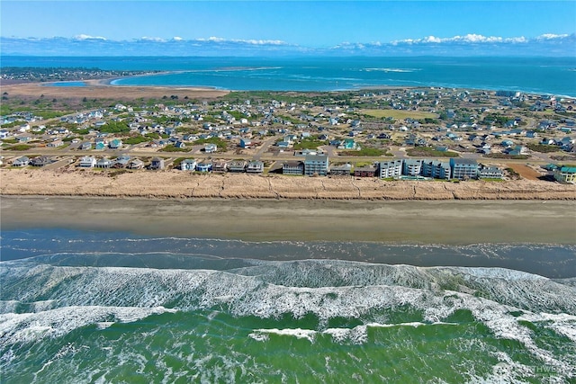 birds eye view of property with a water view and a beach view