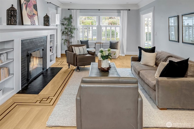 living area with built in shelves, baseboards, wood finished floors, and a tile fireplace