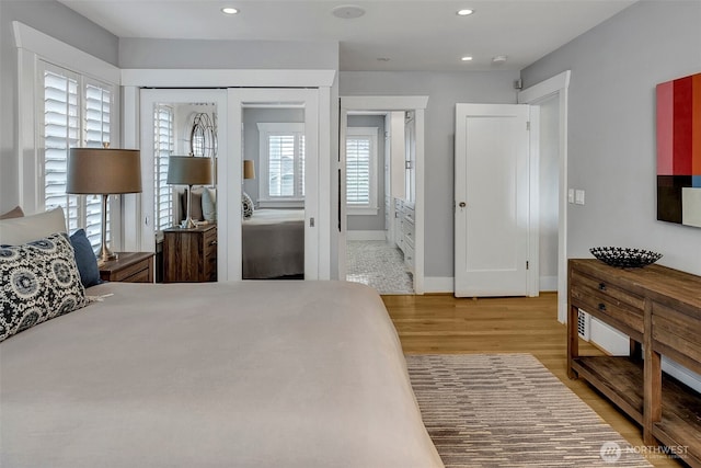 bedroom featuring recessed lighting, wood finished floors, baseboards, and a closet