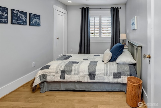 bedroom with baseboards and wood finished floors