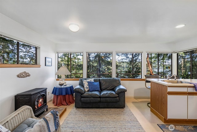 living area featuring recessed lighting and a wood stove