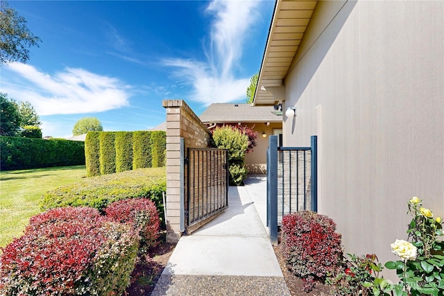 view of gate with a yard and fence