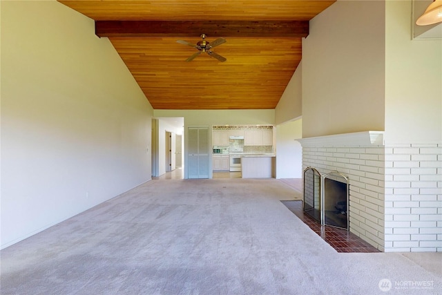 unfurnished living room featuring beamed ceiling, a fireplace, wooden ceiling, and light colored carpet