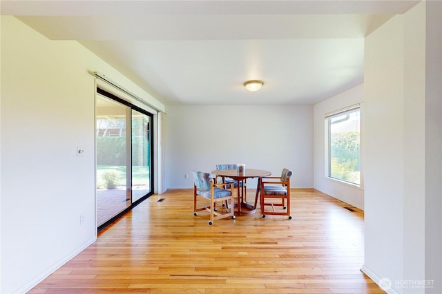 dining room with baseboards and light wood-style floors