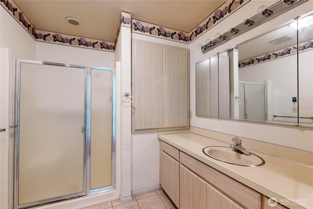 bathroom with a stall shower, tile patterned flooring, and vanity