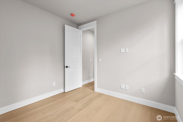 spare room with light wood finished floors and baseboards