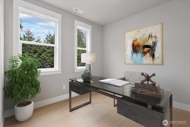 office area featuring light wood-style flooring, visible vents, and baseboards