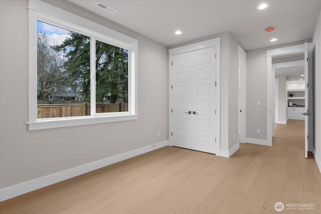 unfurnished bedroom featuring baseboards, visible vents, light wood-style floors, a closet, and recessed lighting