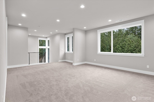 spare room featuring carpet floors, recessed lighting, a wealth of natural light, and visible vents