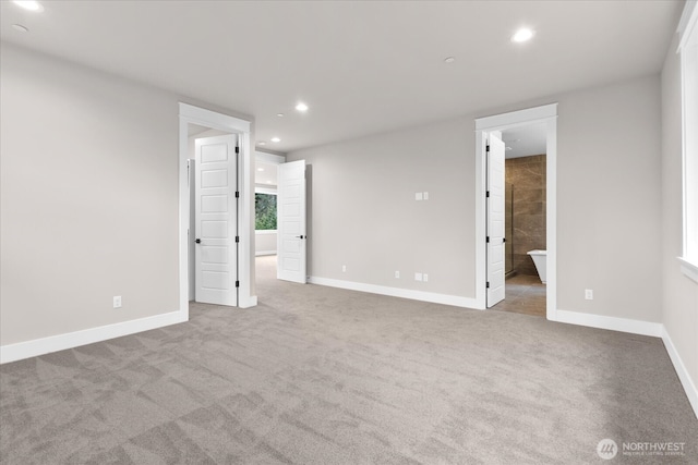 unfurnished bedroom with baseboards, ensuite bathroom, carpet flooring, and recessed lighting