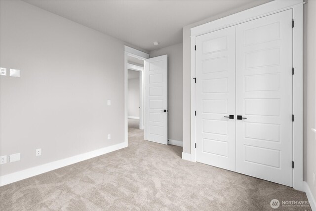 unfurnished bedroom with carpet, baseboards, and a closet