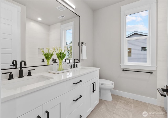 bathroom featuring toilet, baseboards, visible vents, and a sink