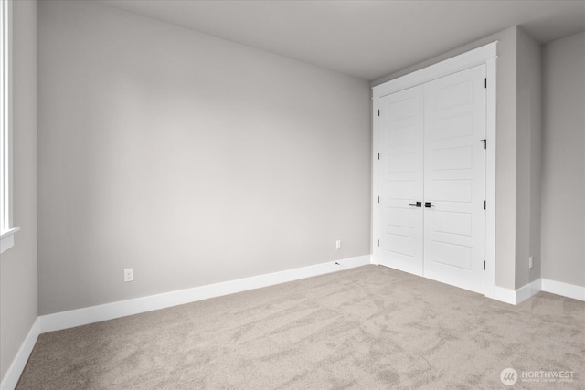 unfurnished bedroom featuring a closet, carpet flooring, and baseboards