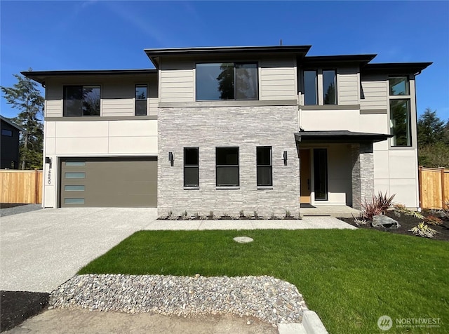 view of front of home featuring concrete driveway, an attached garage, fence, and stone siding