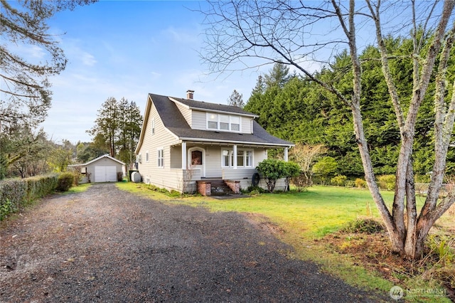 bungalow with an outbuilding, a front yard, driveway, a chimney, and a detached garage