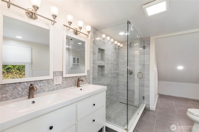 full bathroom with tile patterned floors, a stall shower, double vanity, and a sink