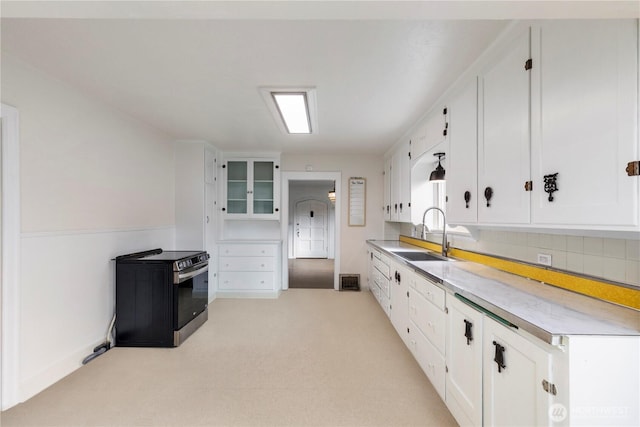 kitchen featuring light colored carpet, light countertops, decorative backsplash, white cabinetry, and a sink