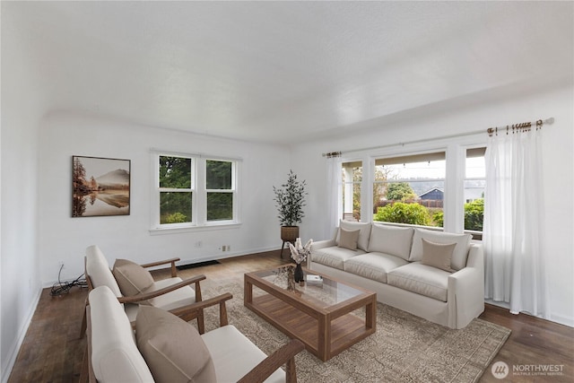 living area with baseboards and wood finished floors