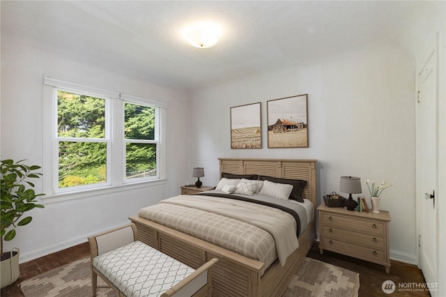 bedroom with dark wood finished floors and baseboards