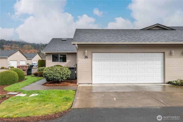 view of front of property with concrete driveway, roof with shingles, and central AC