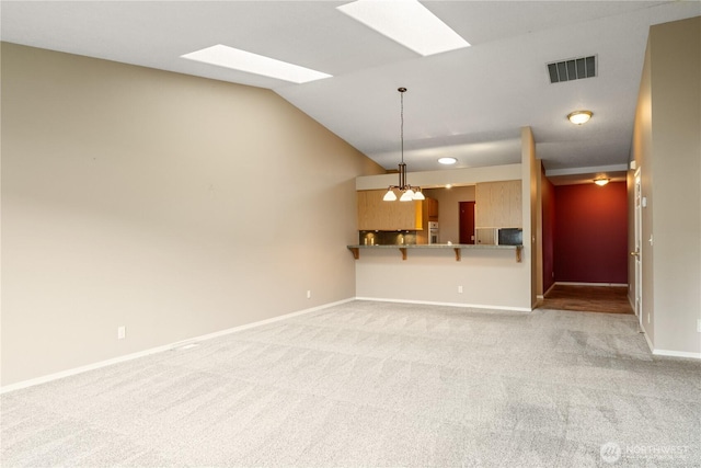 unfurnished living room with light colored carpet, visible vents, vaulted ceiling, and baseboards