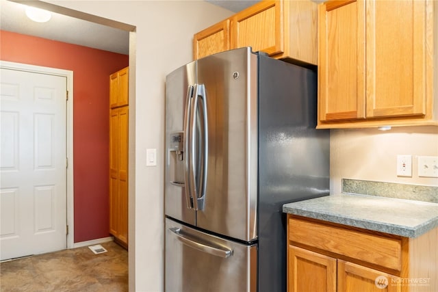 kitchen featuring light countertops, visible vents, and stainless steel fridge with ice dispenser