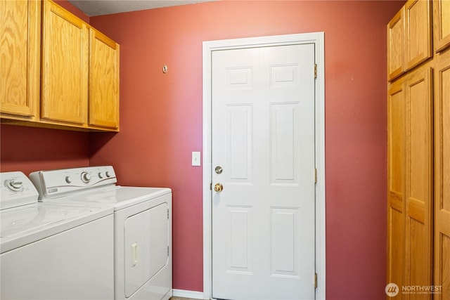 clothes washing area featuring cabinet space and washer and dryer