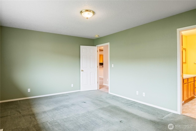 carpeted spare room featuring baseboards