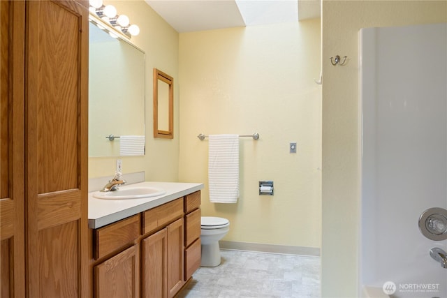 full bathroom with bathing tub / shower combination, vanity, toilet, and baseboards