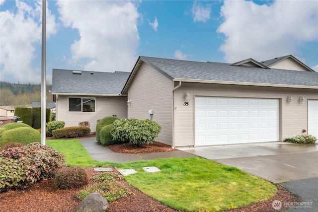 view of front of house with driveway, a shingled roof, and an attached garage