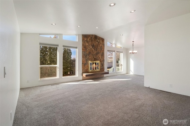 unfurnished living room with vaulted ceiling, carpet floors, a fireplace, and a chandelier