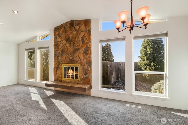 unfurnished living room with lofted ceiling, an inviting chandelier, carpet, and a stone fireplace