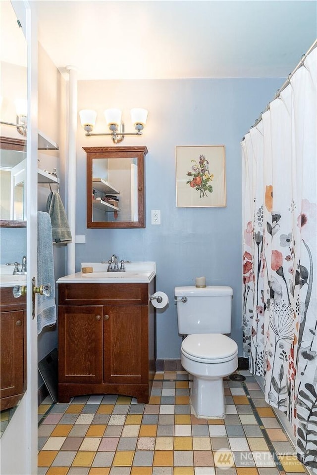 full bath with toilet, curtained shower, tile patterned floors, and vanity