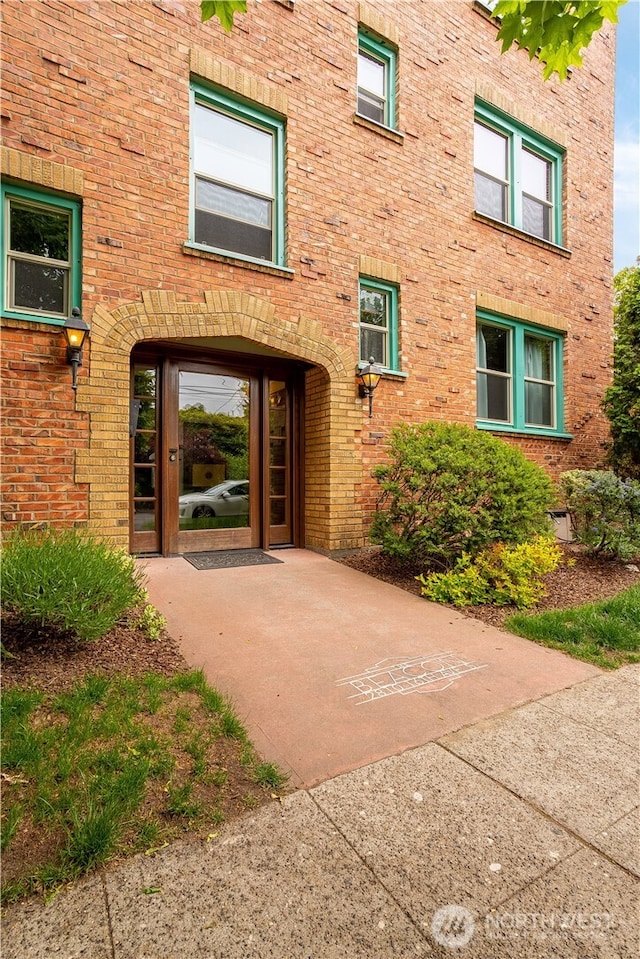 doorway to property with brick siding