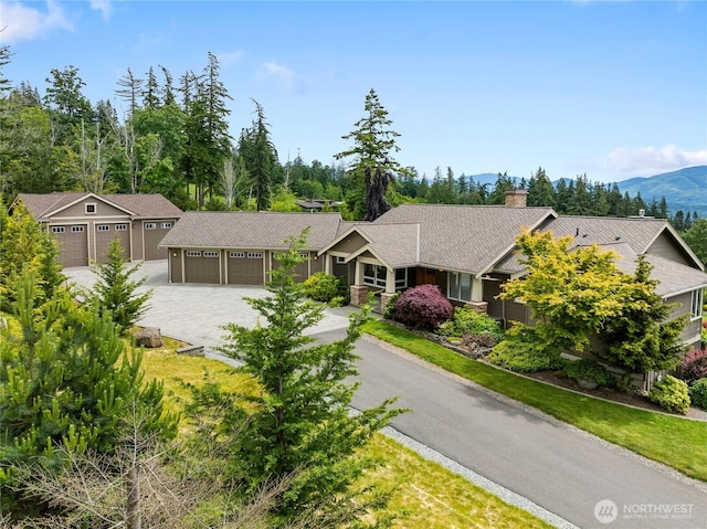 ranch-style house with driveway, an attached garage, and a chimney