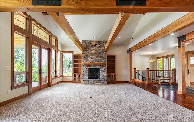 carpeted living area featuring high vaulted ceiling, beam ceiling, a stone fireplace, and baseboards