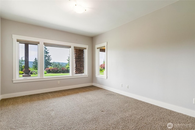 unfurnished room featuring carpet floors and baseboards