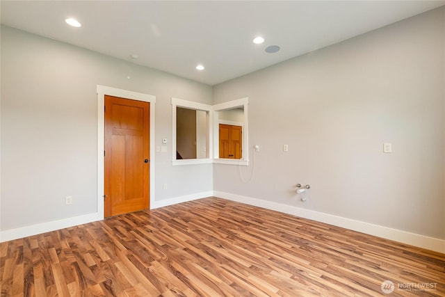 unfurnished room with baseboards, wood finished floors, and recessed lighting