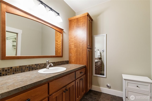 bathroom featuring tasteful backsplash, tile patterned flooring, vanity, and baseboards