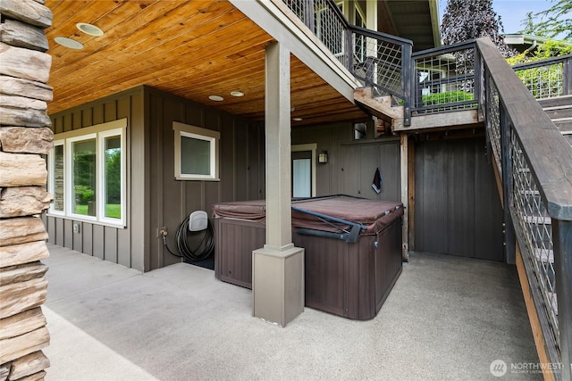 view of patio / terrace featuring a hot tub and stairway