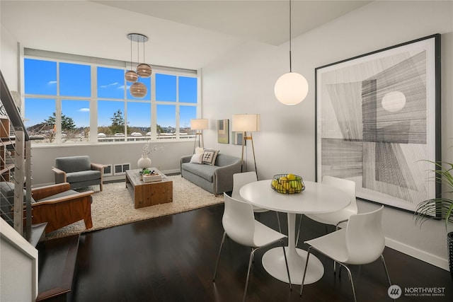 dining room featuring visible vents, wood finished floors, and baseboards