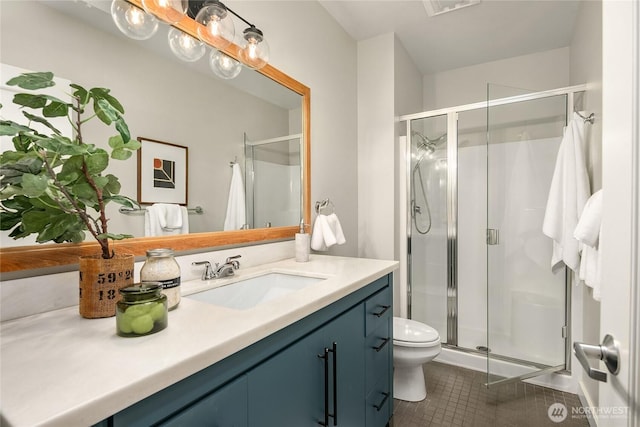 full bath with tile patterned floors, vanity, a shower stall, and toilet