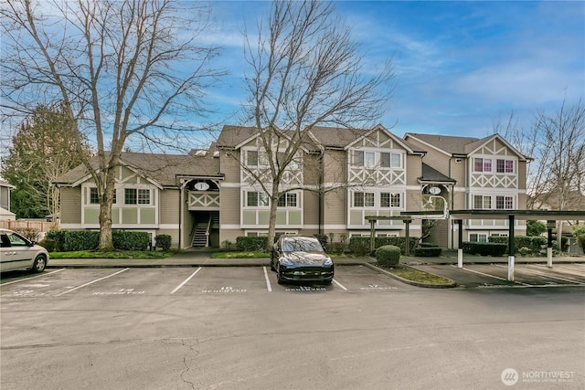 view of building exterior featuring uncovered parking and a residential view