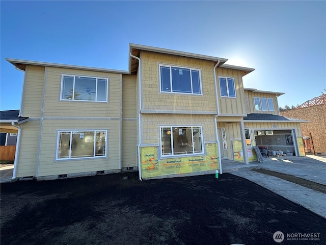 view of front of property with board and batten siding, crawl space, an attached garage, and concrete driveway