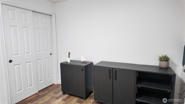 laundry area with dark wood-type flooring