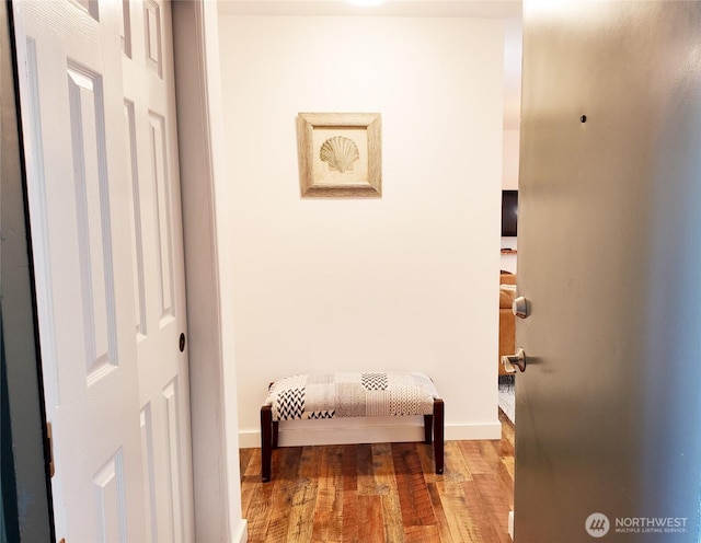 corridor with hardwood / wood-style flooring and baseboards