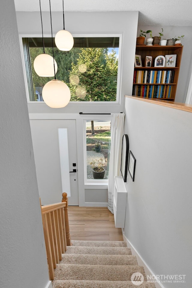 staircase featuring baseboards and wood finished floors