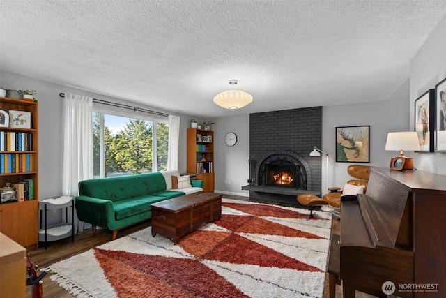 living room with wood finished floors, a fireplace, and a textured ceiling