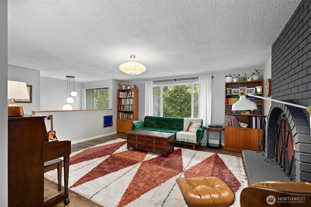 living area with wood finished floors, baseboards, and a textured ceiling