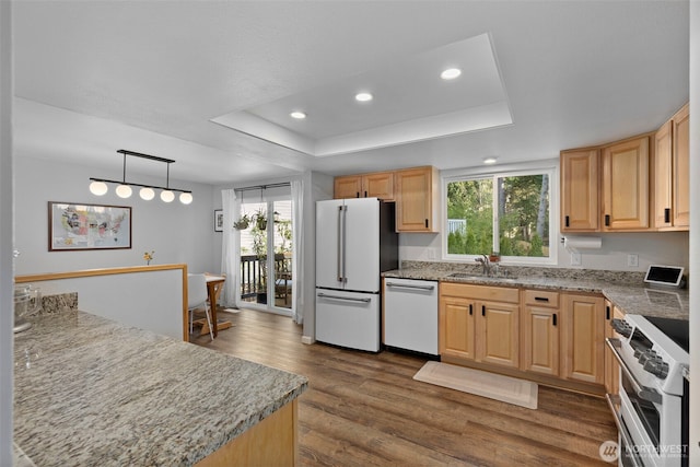 kitchen featuring a sink, dark wood-style floors, recessed lighting, white appliances, and a raised ceiling